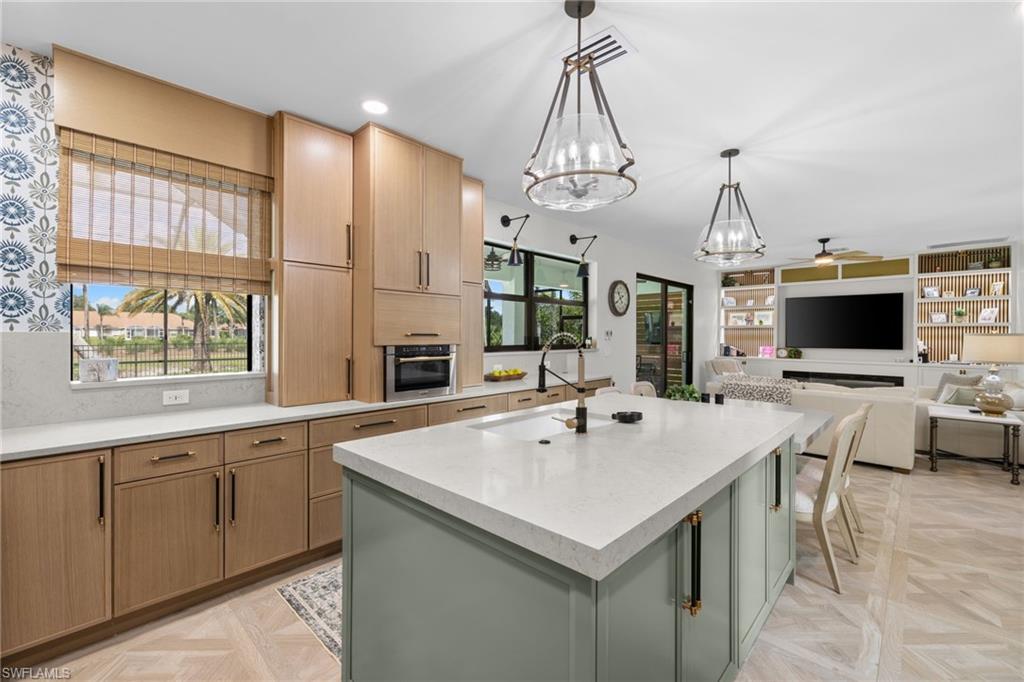 Open-concept kitchen and living area featuring a large center island with a light-colored countertop