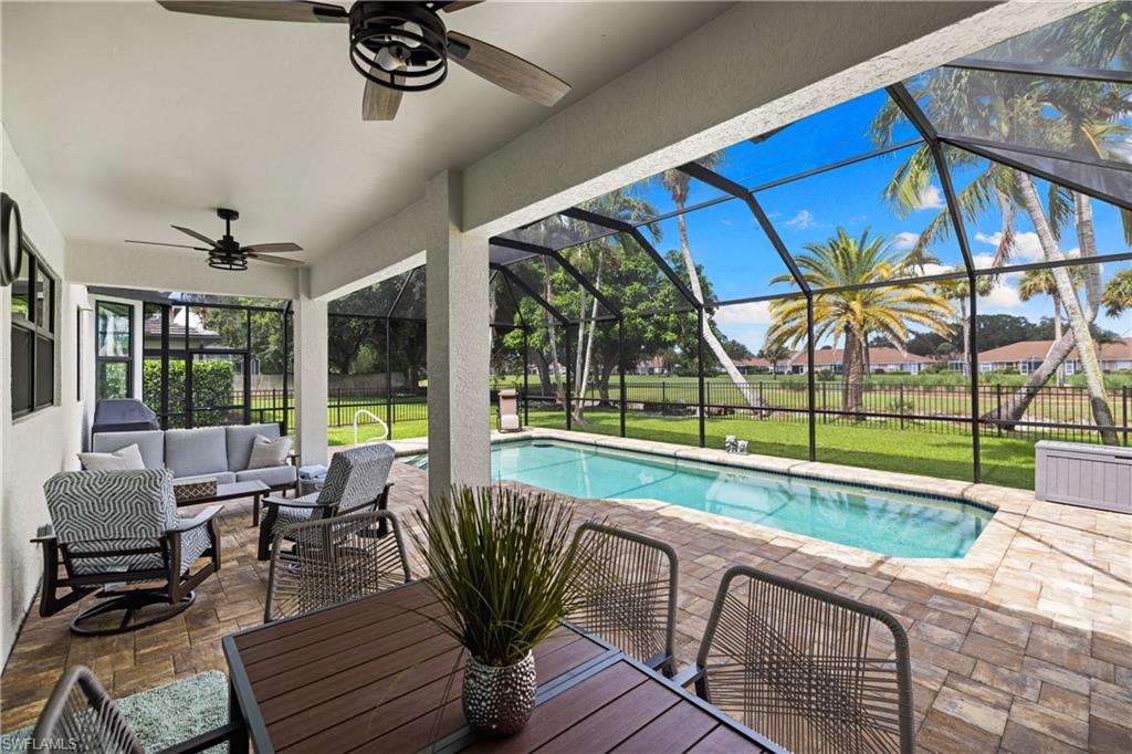 Screened patio with a rectangular swimming pool, brick paver decking, and an expansive lawn
