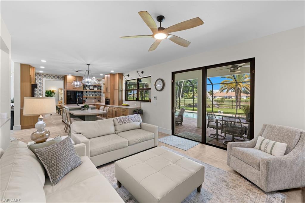 Living area featuring large format tile flooring, a ceiling fan with integrated lighting, and expansive sliding glass doors