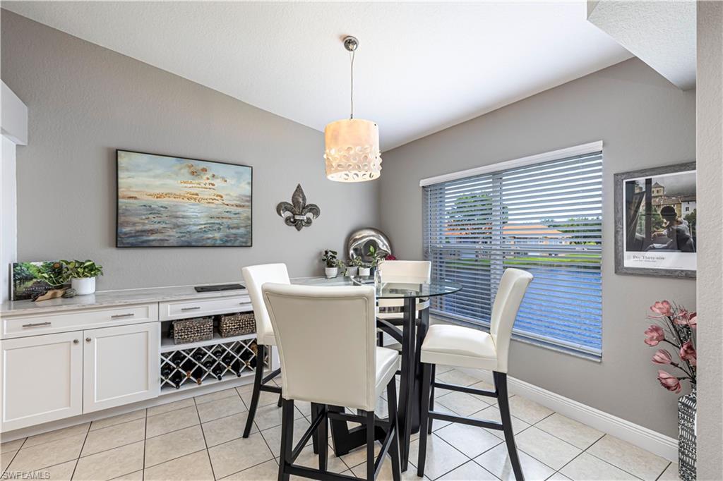 Dining area featuring a vaulted ceiling and tile flooring