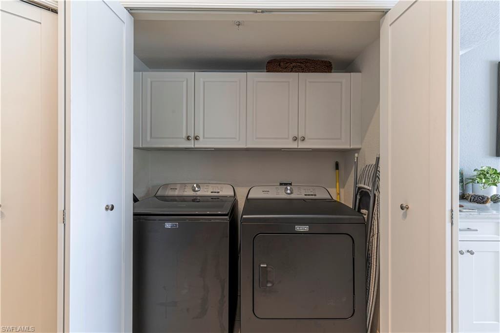 Dedicated laundry closet with white shaker-style cabinetry and a shelf