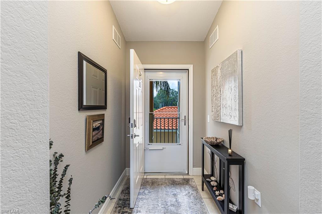 Entryway featuring neutral wall tones, white trim, and tile flooring