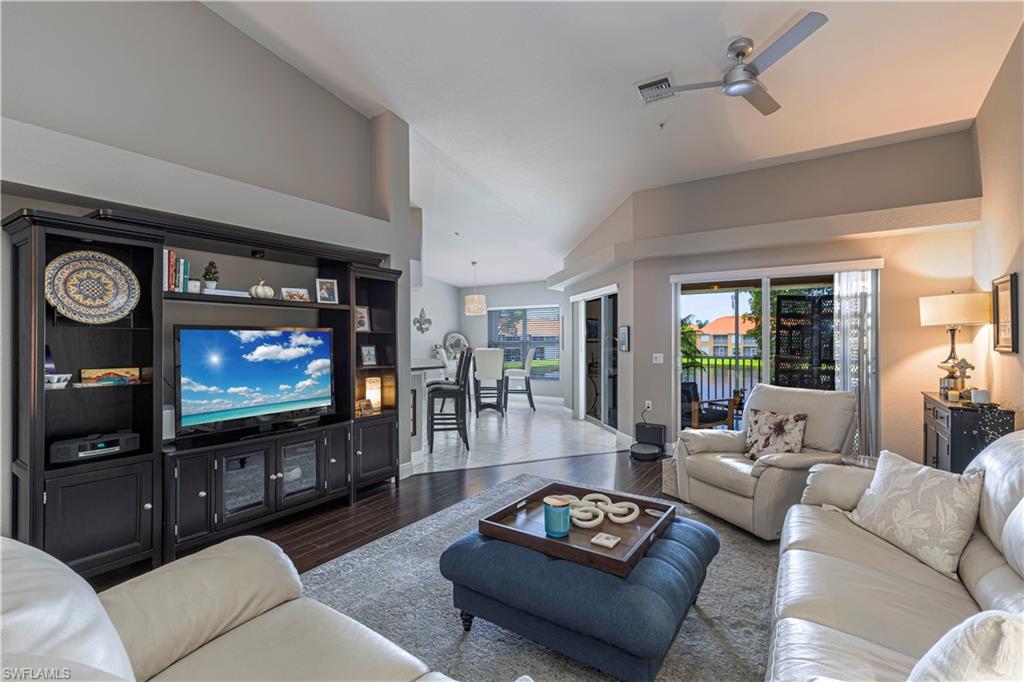 Living area featuring dark wood-finish flooring, a contemporary ceiling fan, and sliding glass doors opening to an outdoor space