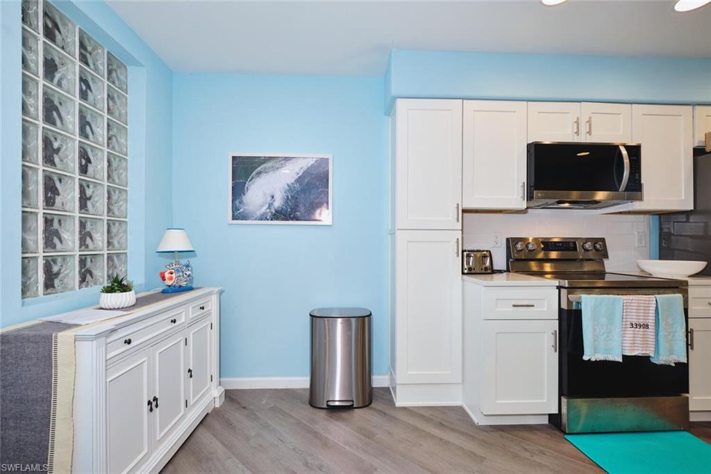 Kitchen featuring stainless steel appliances, light wood finished floors, and white cabinets