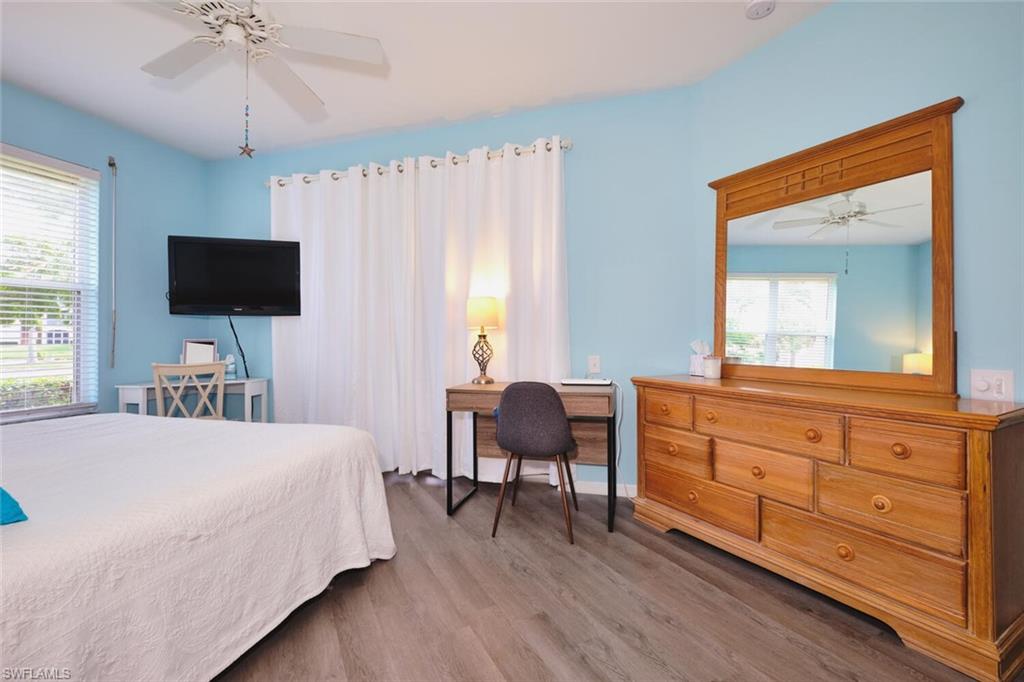 Bedroom featuring wood finished floors, multiple windows, and a ceiling fan