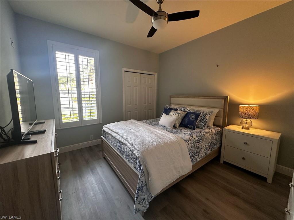 Bedroom with dark wood-style flooring, a closet, and a ceiling fan