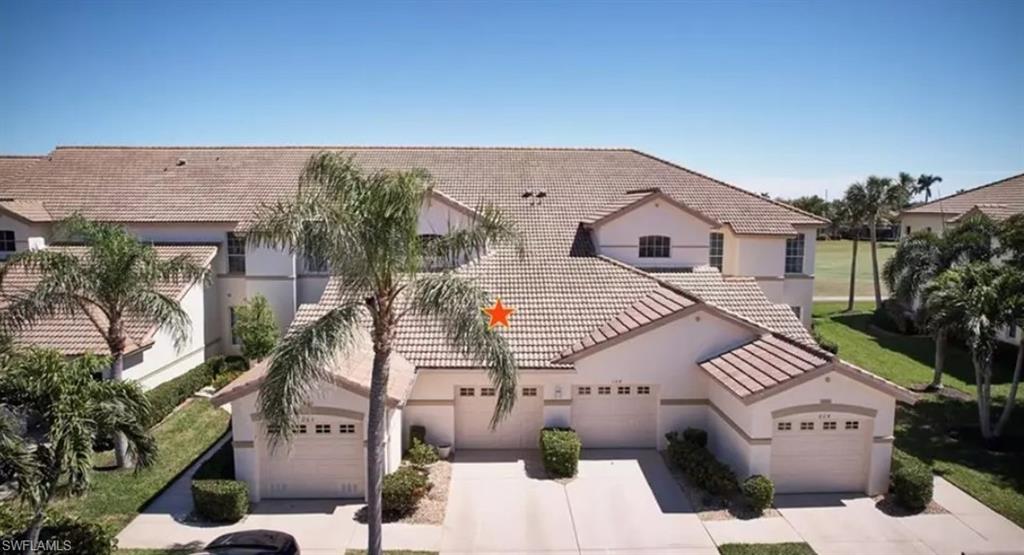 View of front of property featuring stucco siding, a tile roof, driveway, and an attached garage
