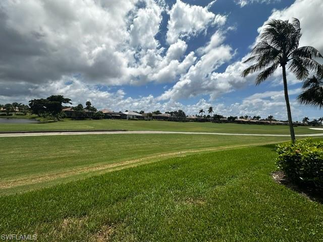 View of home's community with a yard and view of golf course