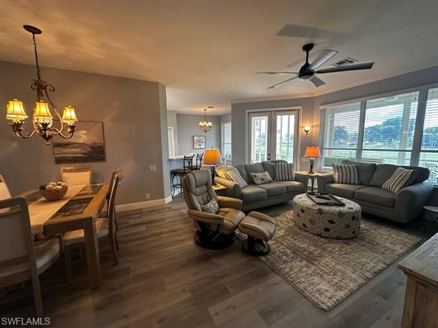 Living area with a chandelier, wood finished floors, and ceiling fan