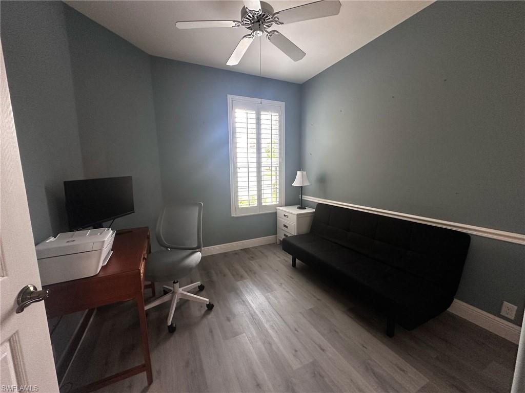 Office area with wood finished floors and ceiling fan