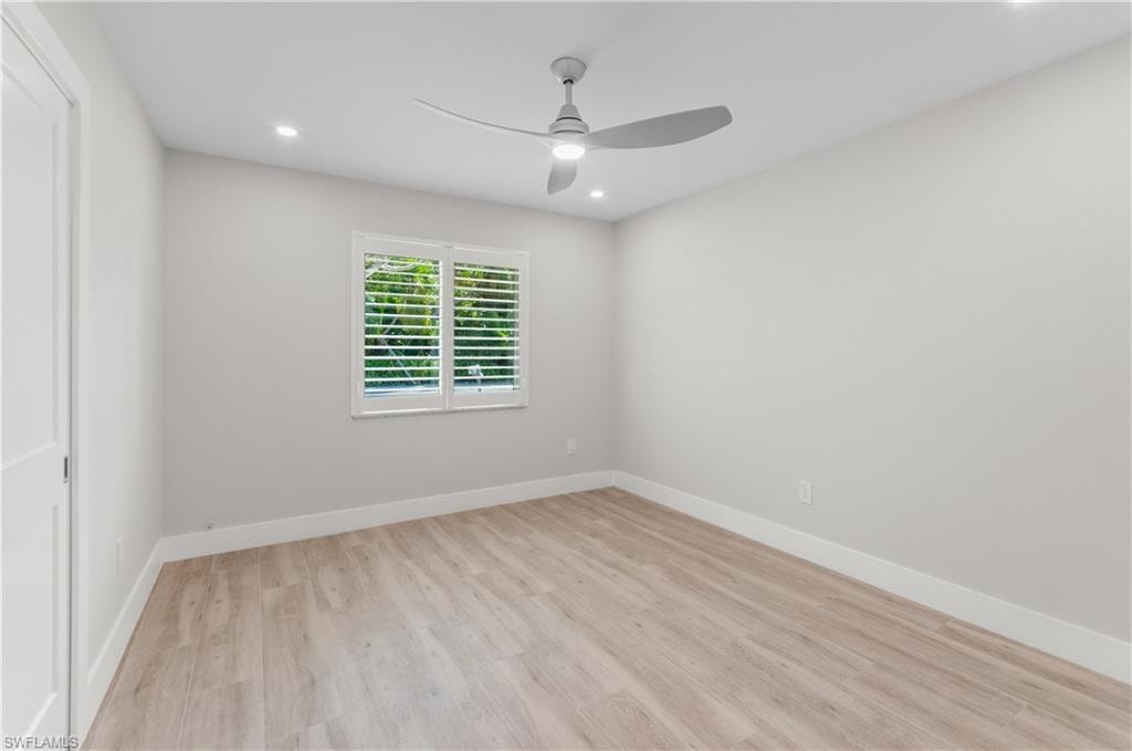 Empty room featuring light wood finished floors, a ceiling fan, and recessed lighting