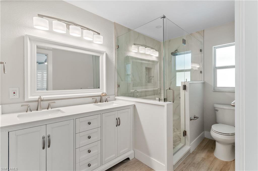 Bathroom#1  featuring double vanity, a marble finish shower, and light wood-style floors