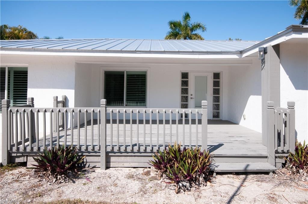 Property entrance with stucco siding and a deck