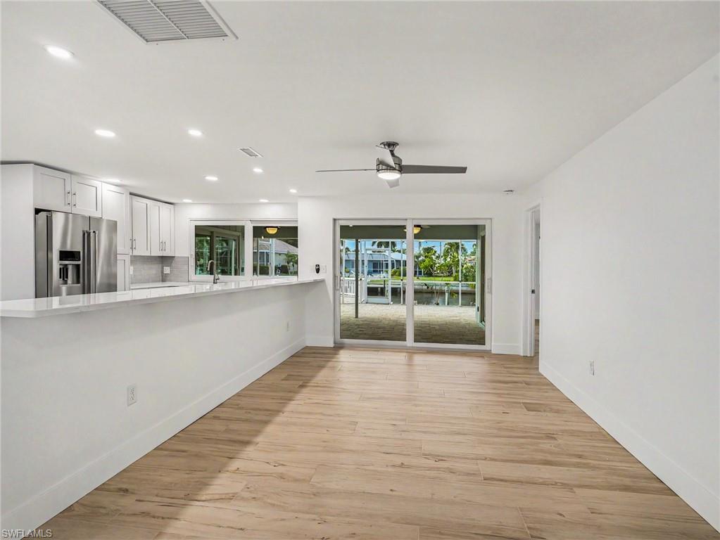 Dining room with ceiling fan, primary bed/bath off to the back right