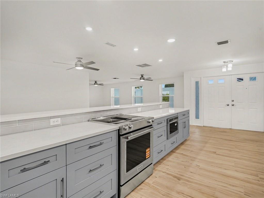 Kitchen overlooking dining/living rooms and front door/foyer