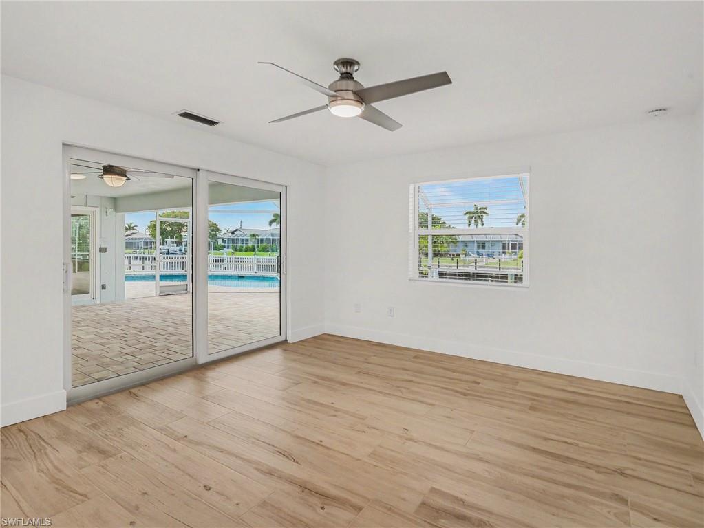 Primary bedroom has sliders to back lanai and overlooks the water
