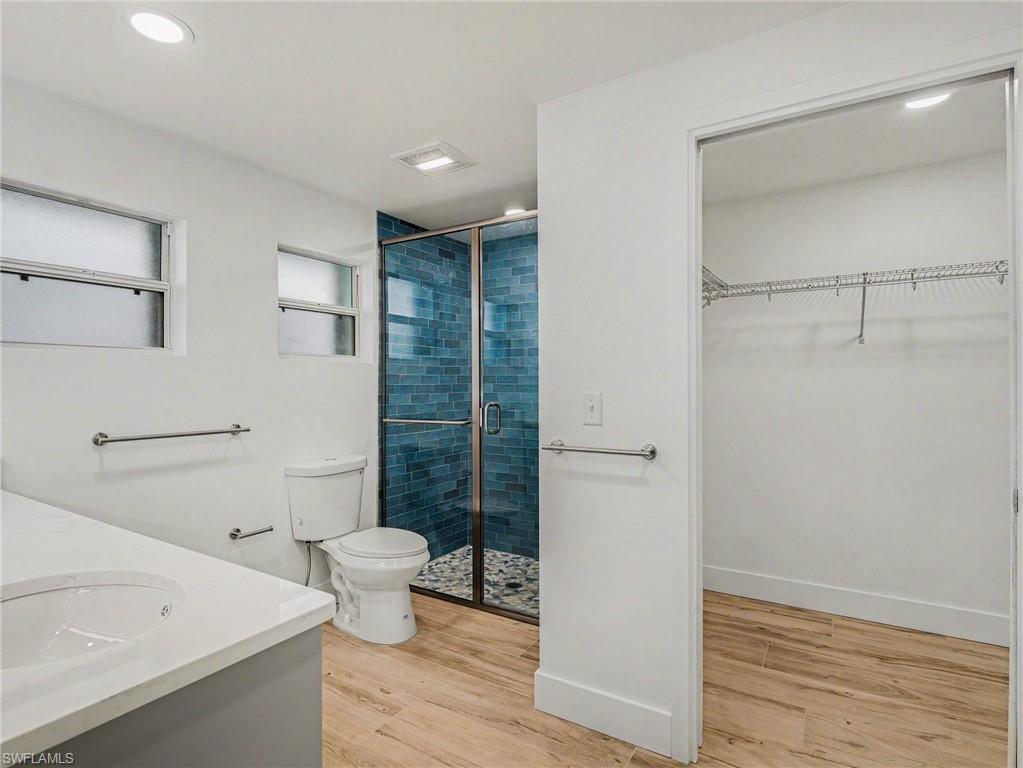 Primary bathroom has beautiful blue tile shower, 7 x 5 ft walk in closet and linen closet