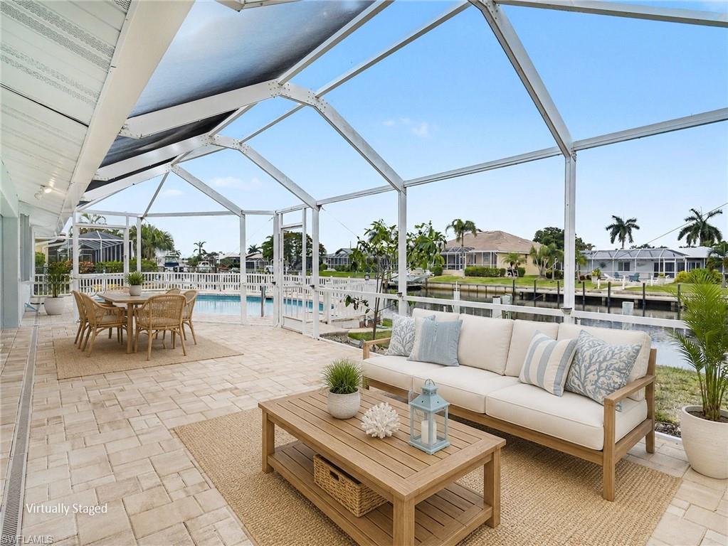 Back lanai extends out another 32 x 13 feet of screened in sun/lounging area overlooking the pool and canal (virtually staged)