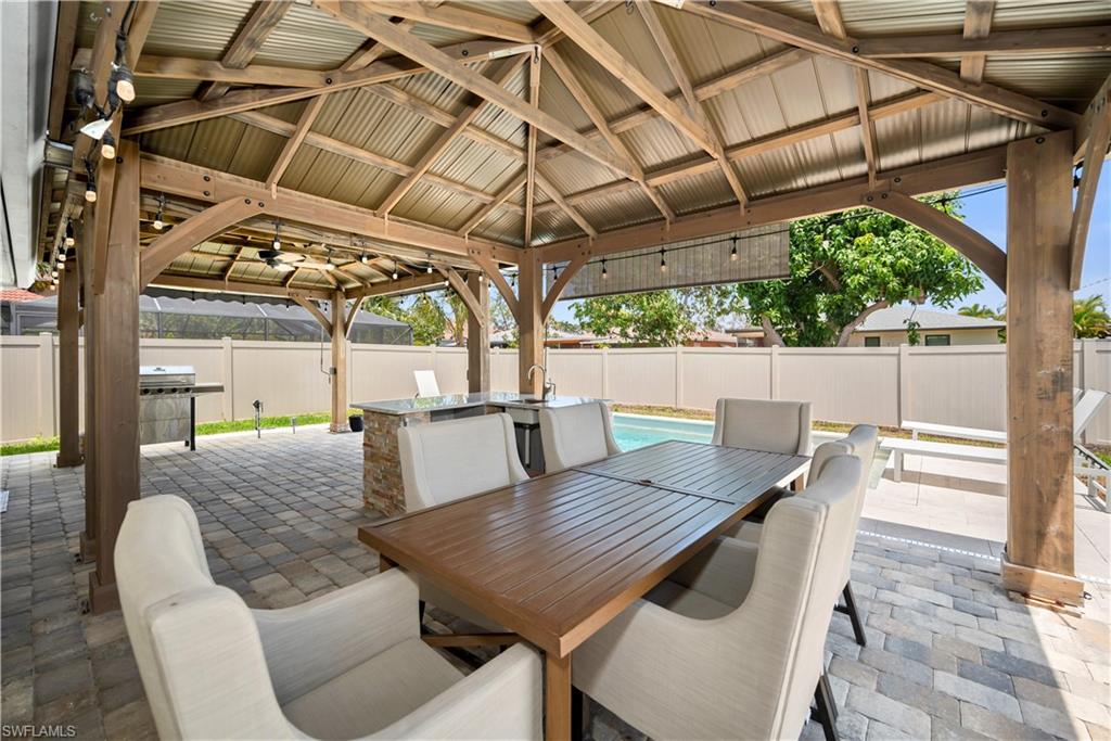 Fenced backyard featuring a gazebo, a patio, and outdoor dining area