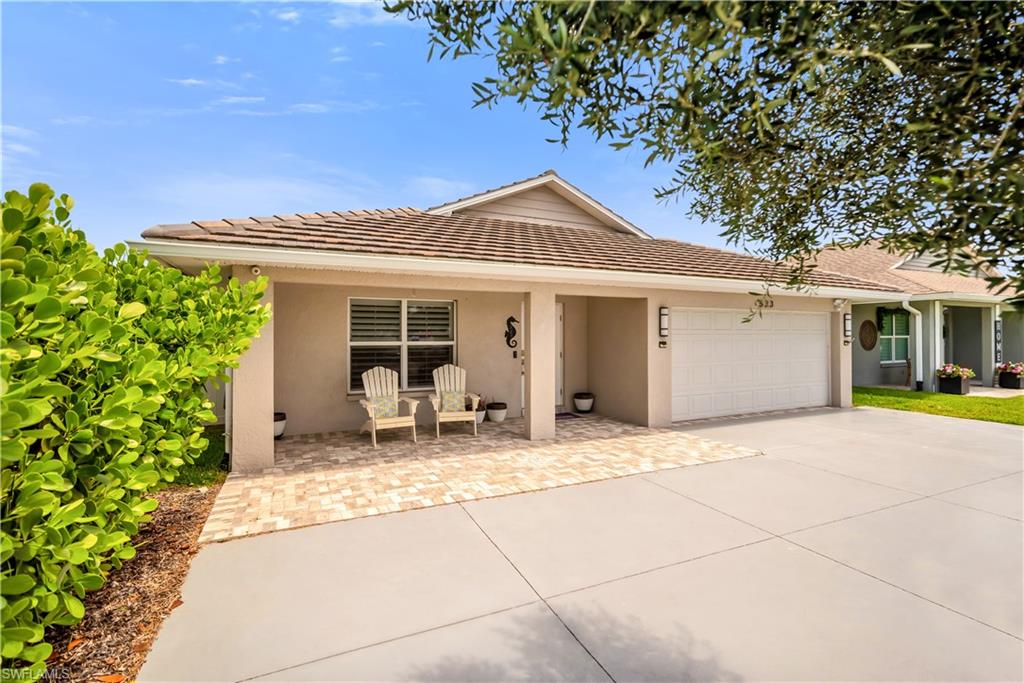 Ranch-style home with stucco siding, a garage, concrete driveway, and a tile roof