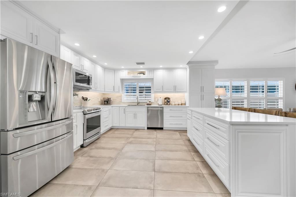 Kitchen featuring stainless steel appliances, a sink, healthy amount of natural light, backsplash, and recessed lighting