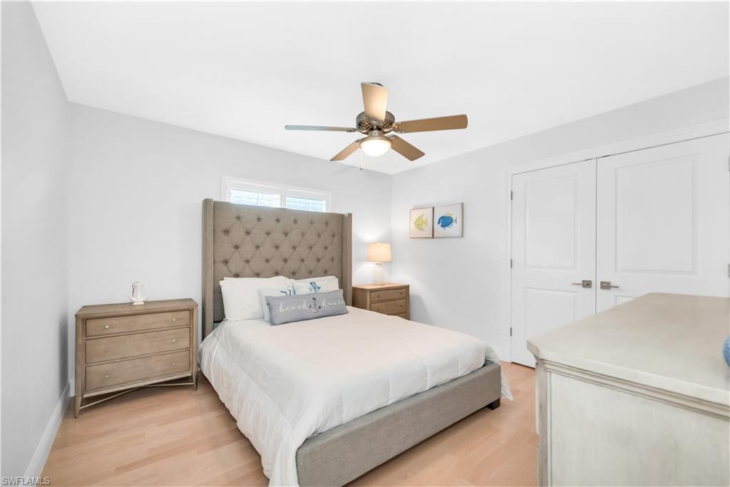 Bedroom with light wood-style floors, a closet, baseboards, and a ceiling fan