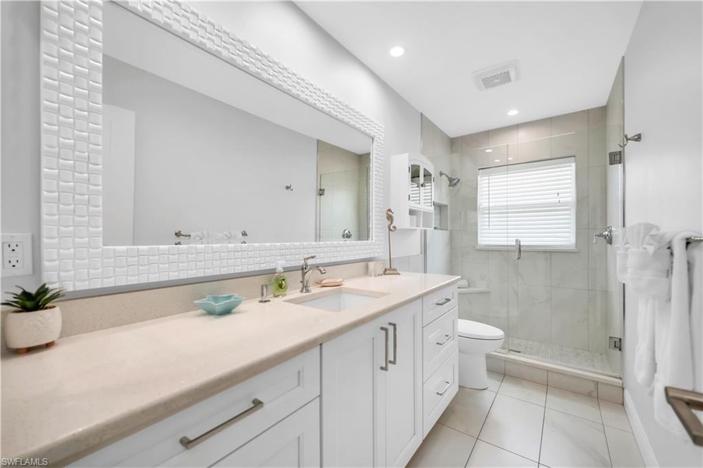 Full bath with toilet, a stall shower, tile patterned flooring, vanity, and recessed lighting