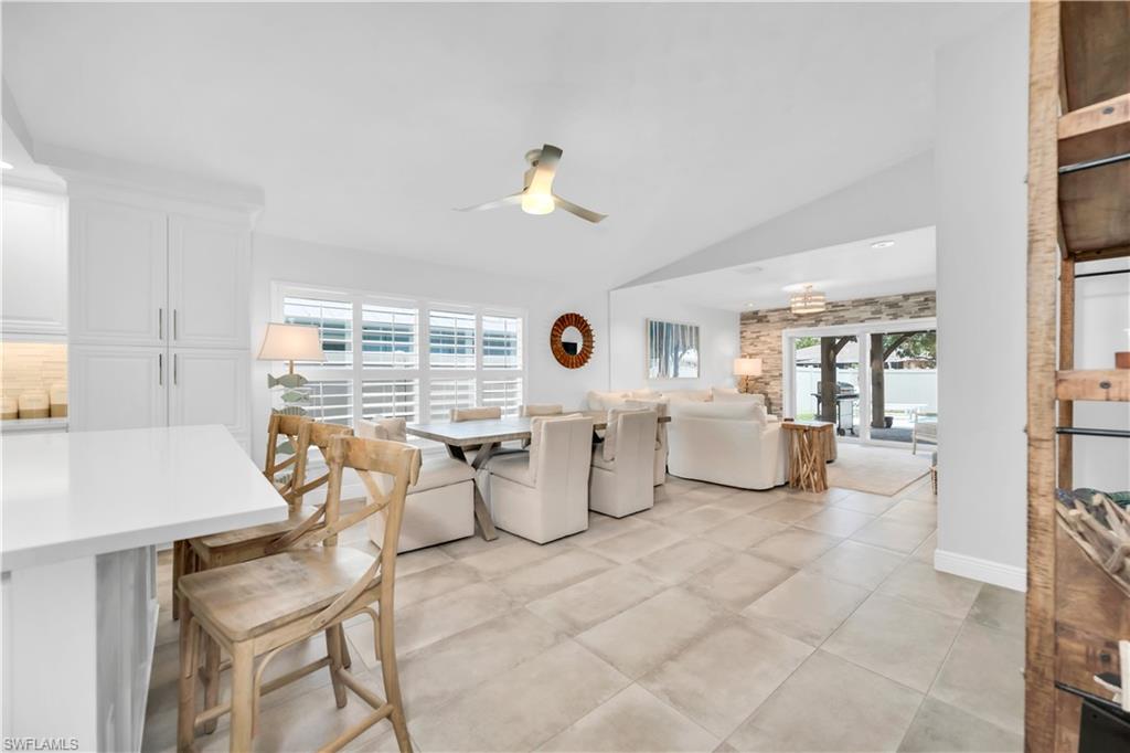 Dining space featuring ceiling fan, lofted ceiling, and plenty of natural light