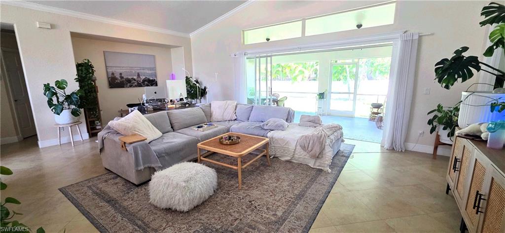 Spacious living area featuring vaulted ceilings, clerestory windows, and light-toned tile flooring