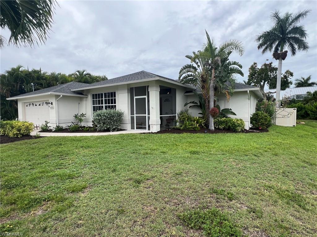 Single-story residence featuring a white exterior with a dark-pitched roof, an attached garage, and a screened entry
