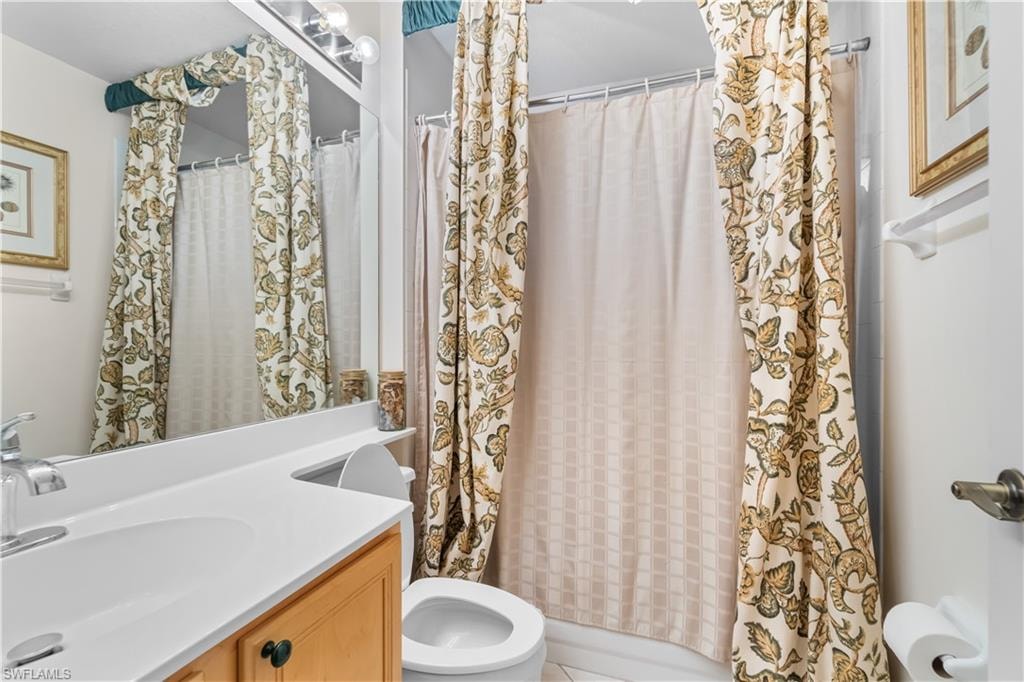 Bathroom featuring vanity, tile patterned flooring, and toilet