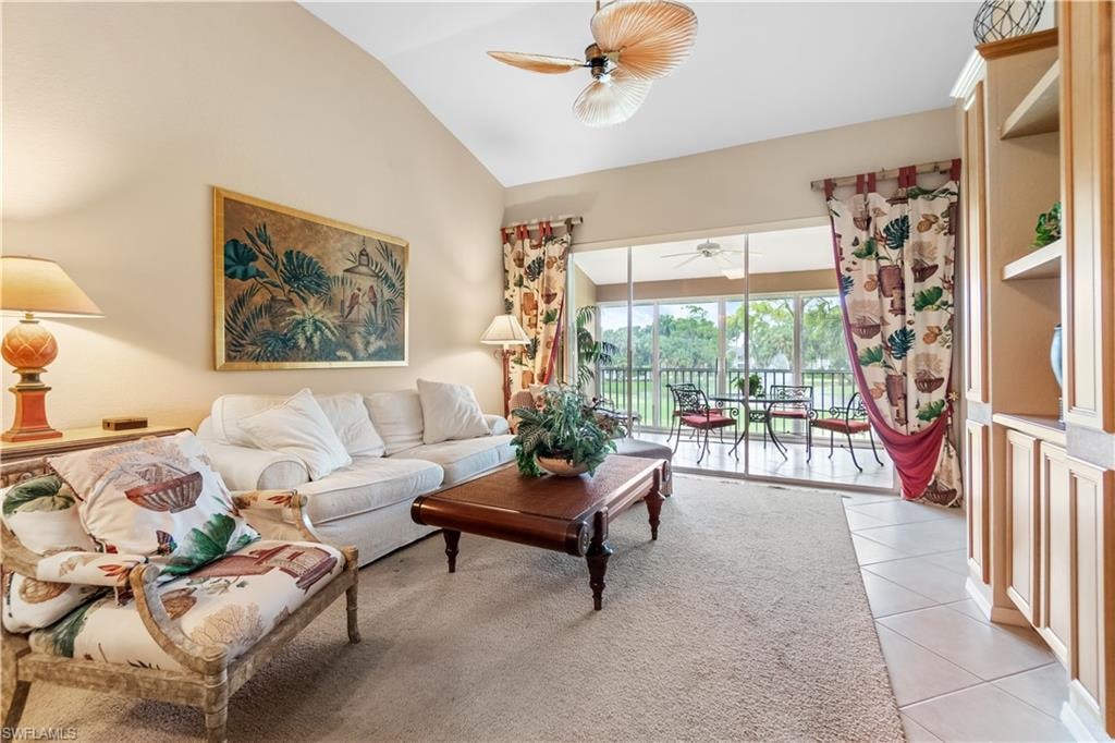 Tiled living room featuring vaulted ceiling and ceiling fan