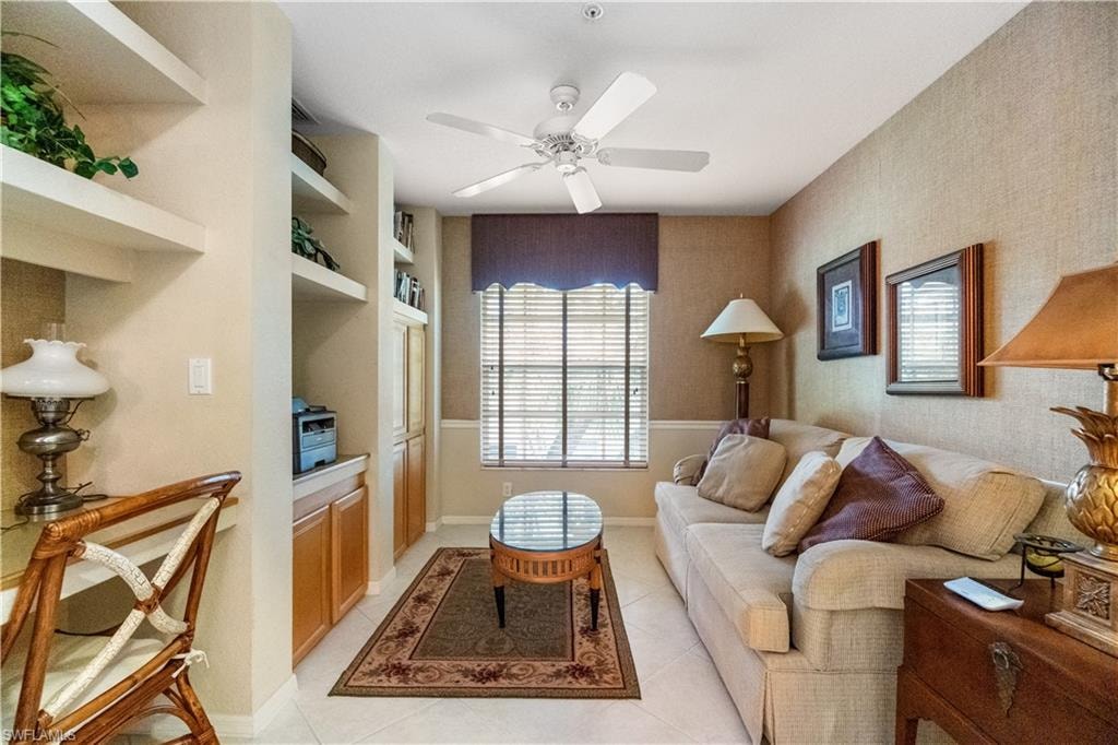 Tiled living room with built in shelves and ceiling fan