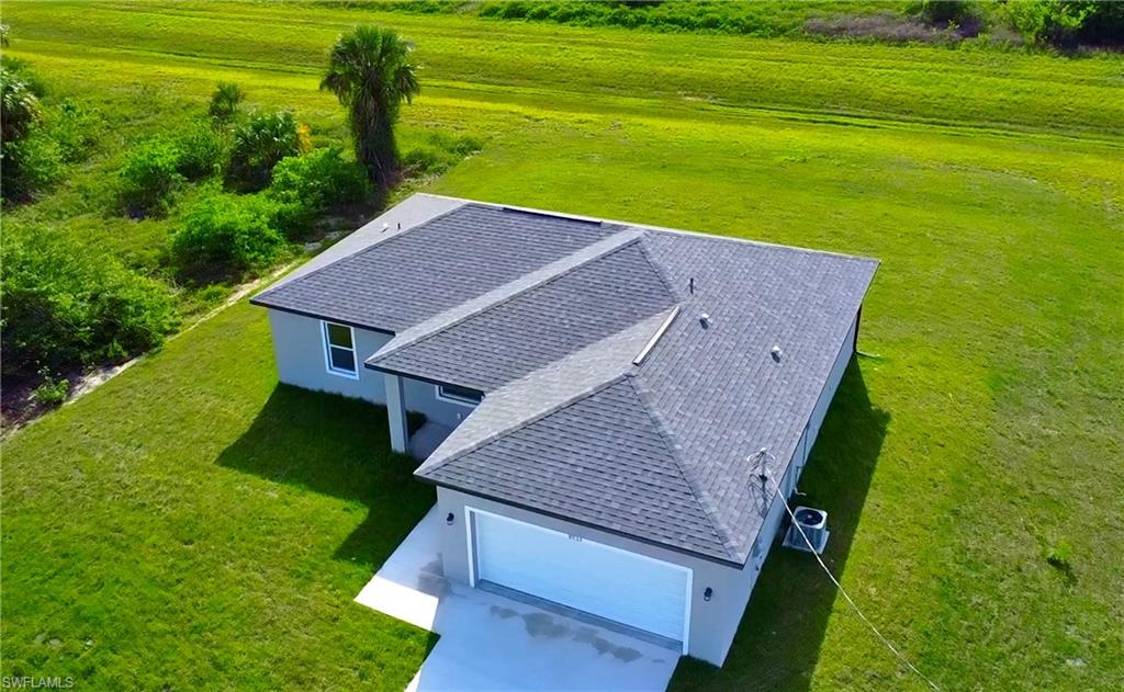 Contemporary single-story residence with a dark shingle roof and light gray stucco exterior