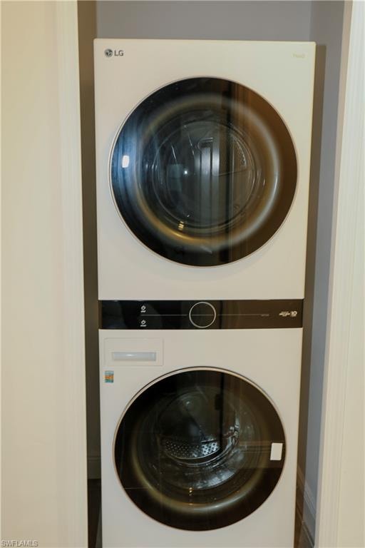 Stackable washer and dryer unit with white finish and dark glass doors