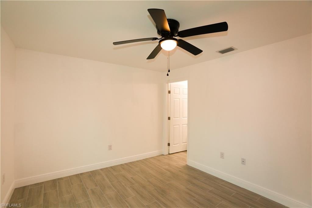 Room featuring light-toned walls and wood-finish flooring