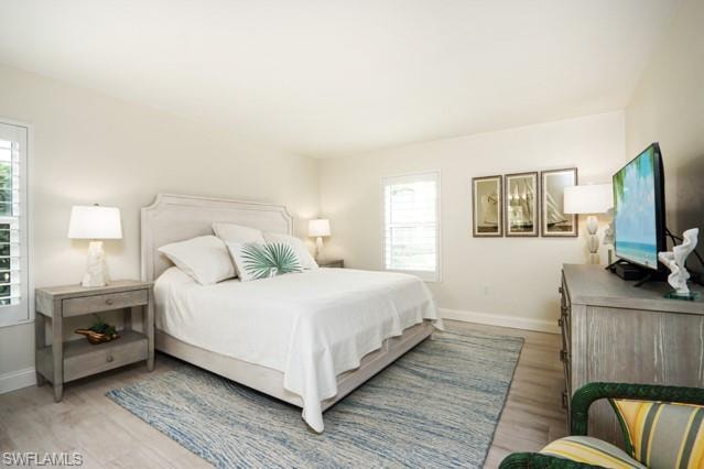 Bedroom with multiple windows and light wood-style flooring