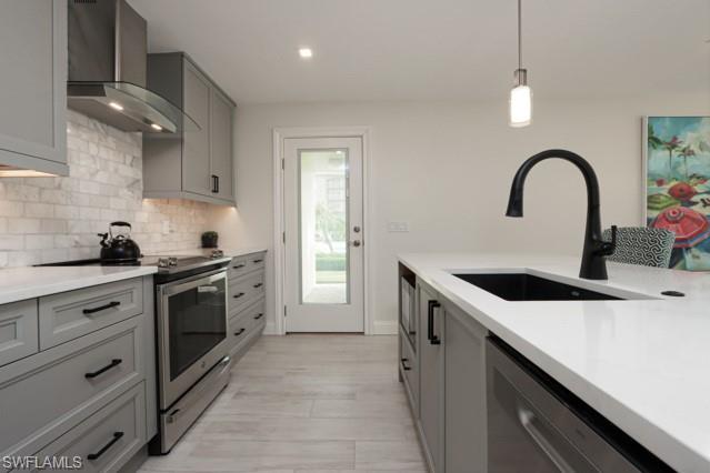 Kitchen featuring gray cabinetry, electric stove, wall chimney range hood, backsplash, and recessed lighting