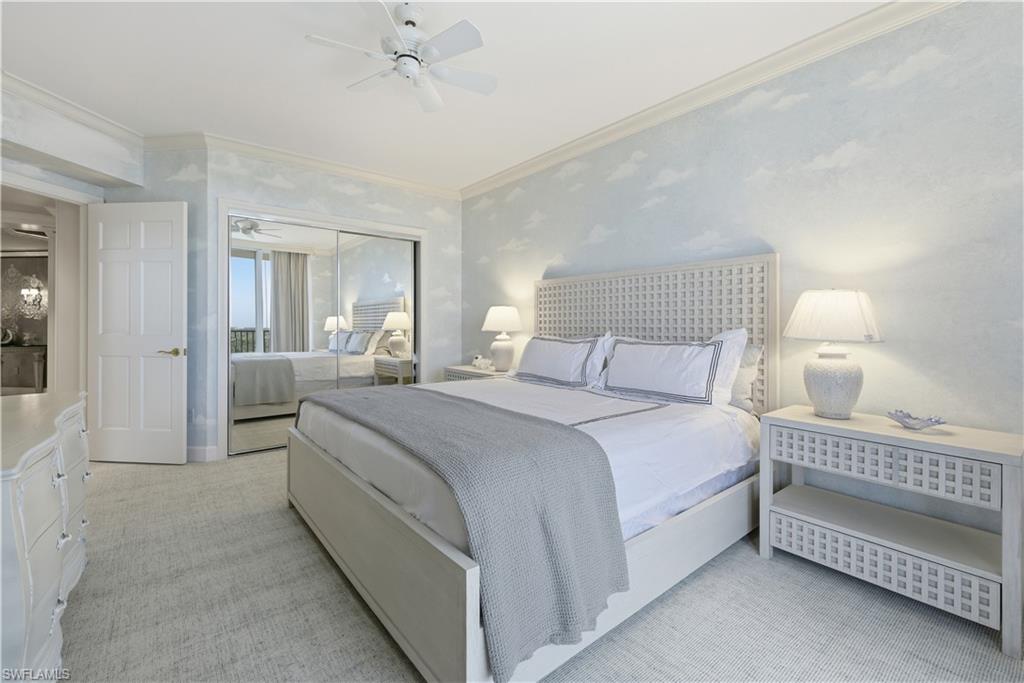 Bedroom with light colored carpet, a closet, crown molding, a ceiling fan, and wallpapered walls