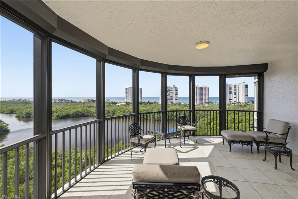 Sunroom featuring a textured ceiling, a textured wall, a water view, tile patterned floors, and floor to ceiling windows