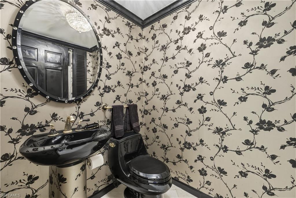 Half bath with light tile patterned floors and wallpapered walls