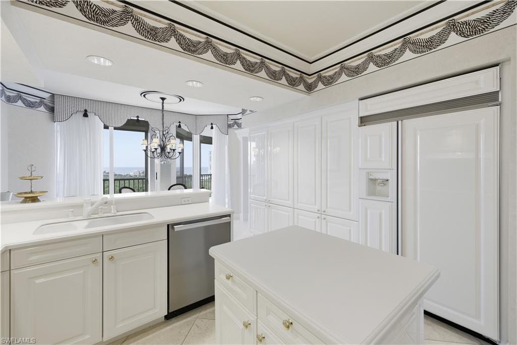 Kitchen featuring paneled built in refrigerator, dishwasher, light countertops, a center island, and white cabinets