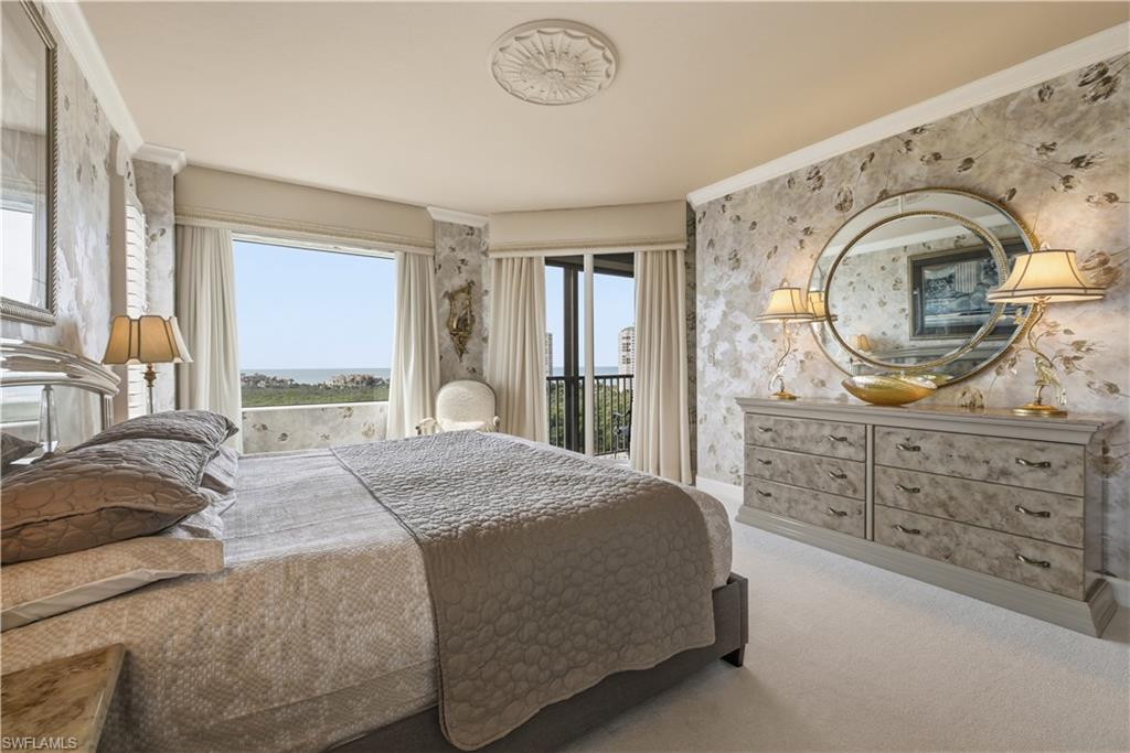 Carpeted bedroom featuring wallpapered walls, crown molding, and access to exterior
