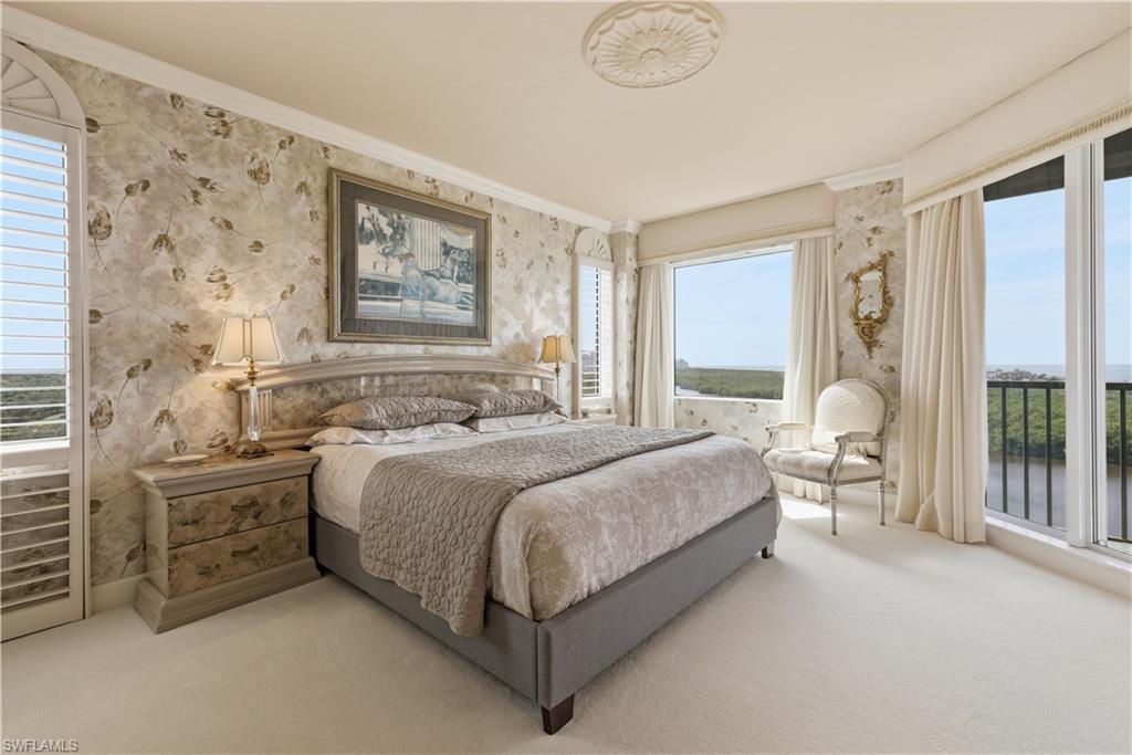 Carpeted bedroom with wallpapered walls and crown molding