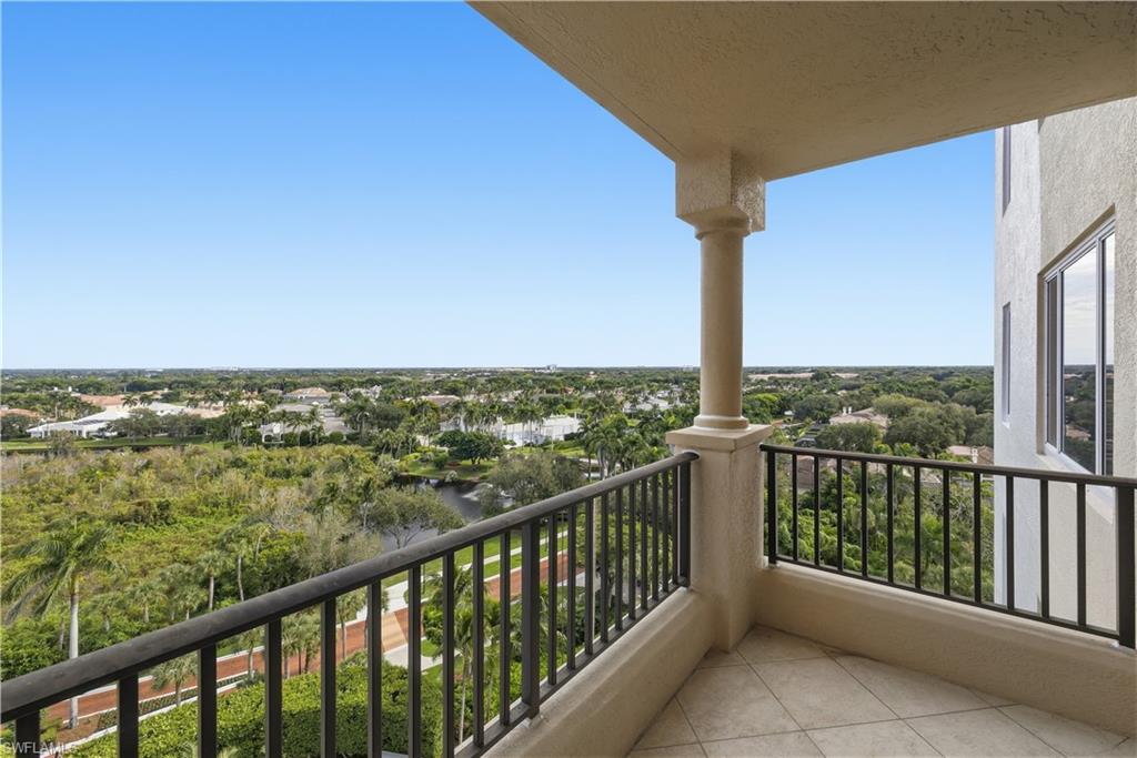 Balcony featuring view of wooded area