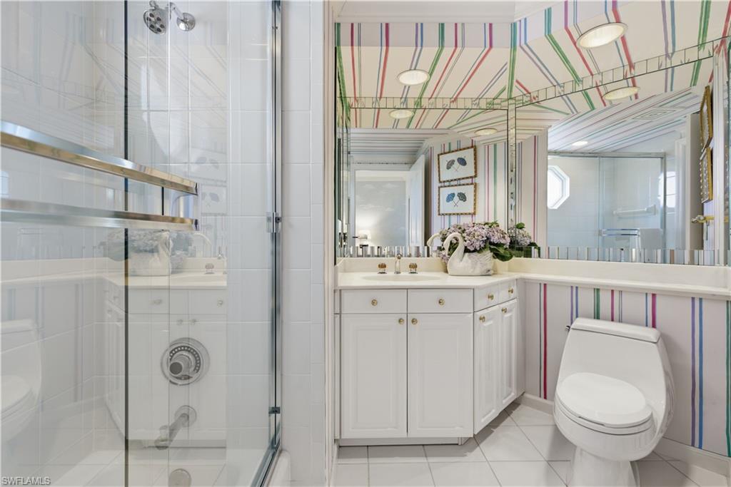 Bathroom featuring light tile patterned floors, vanity, and a stall shower
