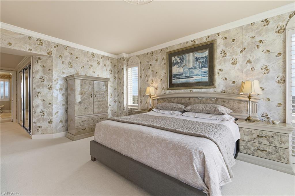 Carpeted bedroom featuring ornamental molding, multiple windows, and wallpapered walls