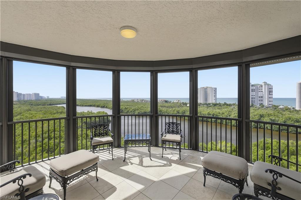 Sunroom / solarium featuring a textured ceiling, a water view, and tile patterned floors