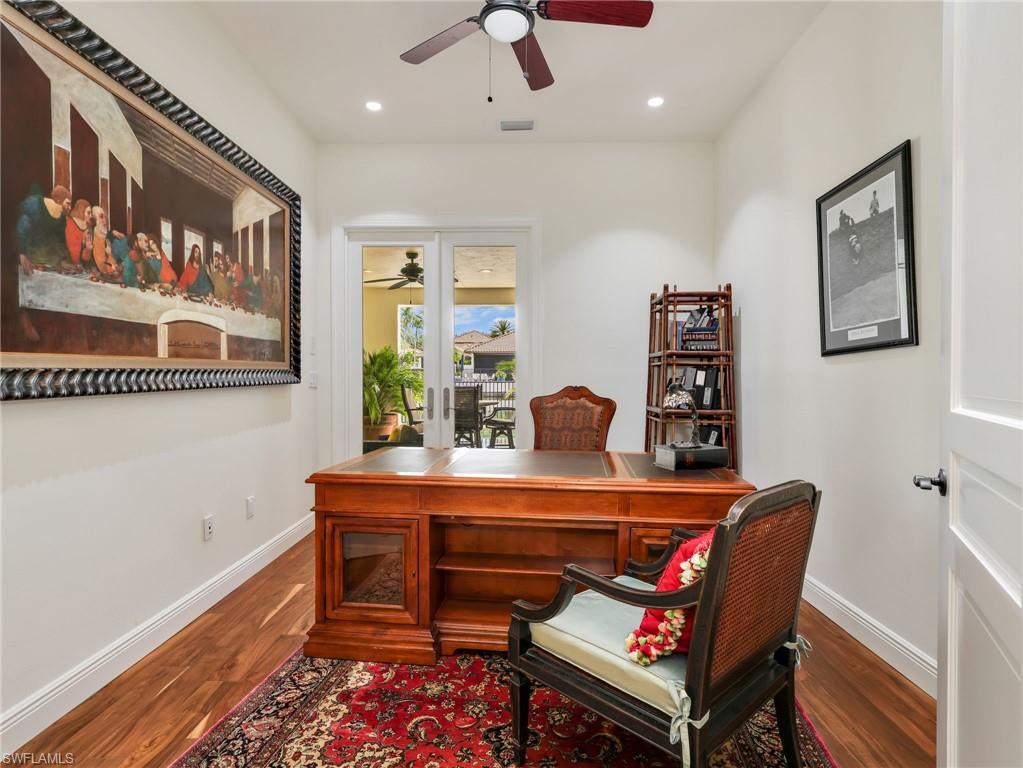 Dedicated office space featuring wood-finish flooring and doors heading out to the private pool/spa