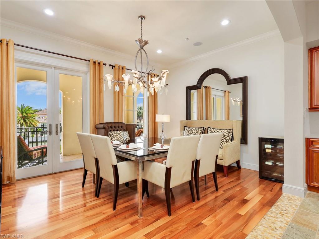 Dining area w/ Brazilian Cherry wood flooring, a contemporary chandelier, and crown molding
